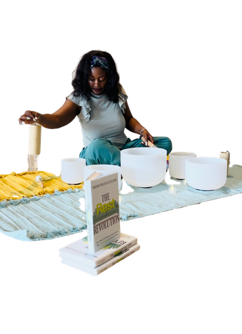 Amanda facilitating a sound bath with crystal bowls, The Rest Revolution displayed beside her